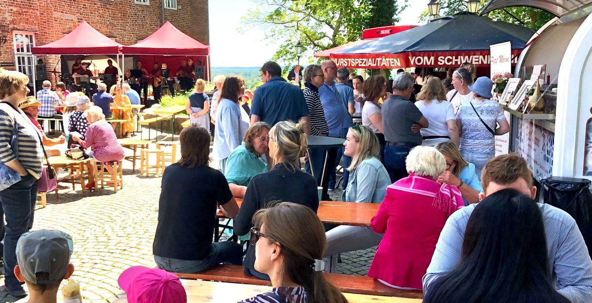 Menschen genießen ein Fest im Freien mit Essensständen und Livemusik in Lauenburg.