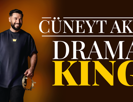 Ein Mann mit Bart und dunklem T-Shirt hält ein Tamburin. Neben ihm steht der Text 'Cüneyt Akan Drama King'.