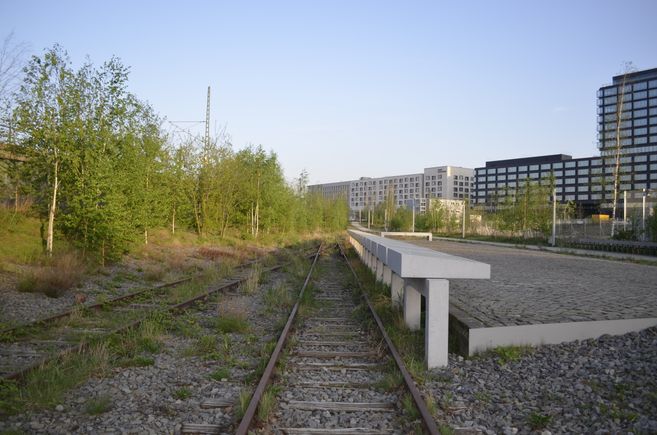 Bahngleise, daneben Gedenktafeln aus Stein
